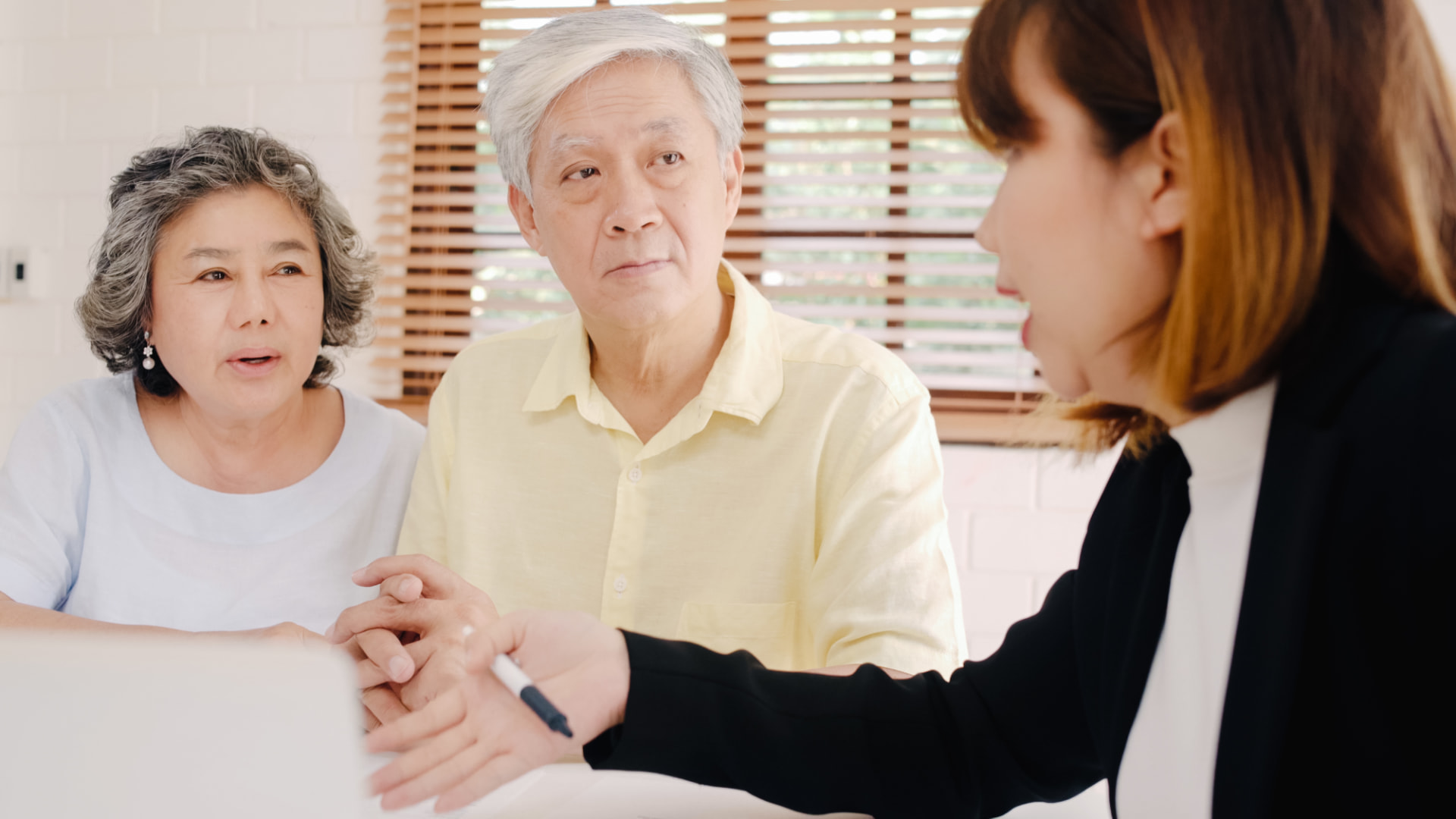 A consultant listening to an older couple at a kitchen table